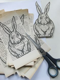 some paper cut outs and scissors on a table with pictures of rabbits in the pages