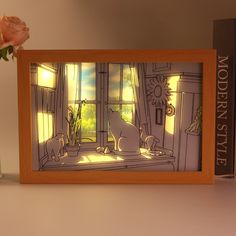 a vase with flowers in it sitting next to a picture frame on a shelf near a book