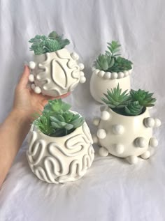 "Handmade decorated indoor wall planter. This planter has a hole in the back to attach to a wall via nail. The back is flat. These off-white ceramic wall planter pots are the ideal gift for any plant lover in your life! They feature 3d sculptural details which makes them a fun piece of home decor for any home, boho, modern, or traditional. 5\" tall, 5\" wide. | White Ceramic Wall Planters, Boho Wall Hanging Planter, Handmade Planter Pot, White Pottery, Minimal Modern Pottery, White Ceramic Plant Retro Clay Art, Texture Pottery Ideas, Boho Clay Art, At Home Clay Projects, Handmade Plant Pot, Pinch Pot Planter, Knick Knacks Aesthetic, Clay Products Ideas, Ceramic Planters Ideas