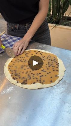 a woman is making an uncooked pizza with chocolate chips on the top and bottom