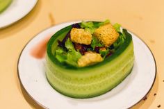 there is a small cucumber with croutons in it on the plate