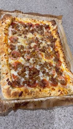 a square pizza sitting on top of a piece of cardboard