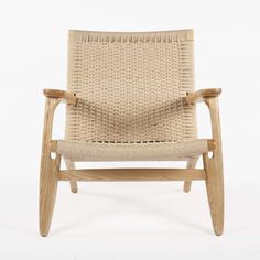 a chair made out of wood and wicker with an armrest that is bent to the side