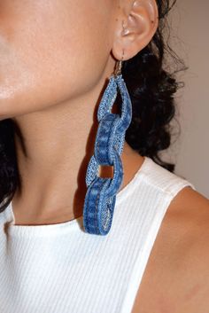 a close up of a person wearing some kind of blue earring on their ear