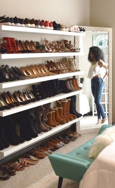 a woman standing in front of a shoe rack filled with lots of pairs of shoes