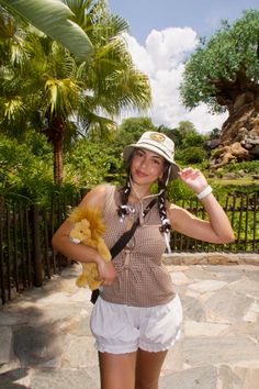 a young woman holding a stuffed animal in her hands while standing next to a fence