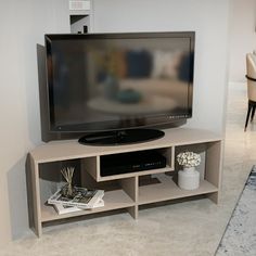 a flat screen tv sitting on top of a wooden entertainment center