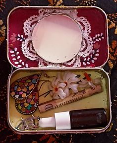 an open tin box with some items inside