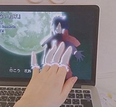 a person using a laptop computer with an animated image on the screen and two hands touching each other's fingers