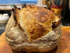 a loaf of bread sitting on top of a wooden cutting board