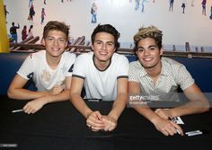 three young men sitting next to each other at a table