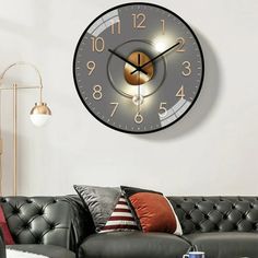 a living room with a black couch and a clock on the wall in front of it