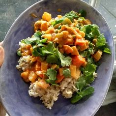 a blue bowl filled with rice and vegetables