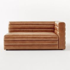 a brown leather couch sitting on top of a white floor