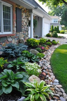 a house with landscaping in front of it and green grass on the ground next to it