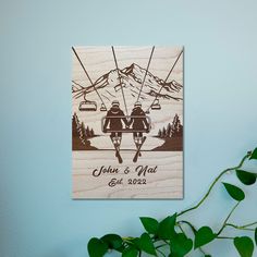 two people sitting on a ski lift in the mountains, holding hands and looking at each other