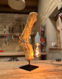 a light that is sitting on top of a wooden table next to a lamp bulb