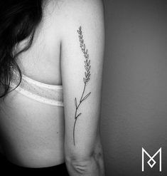 a black and white photo of a woman's arm with a flower tattoo on it