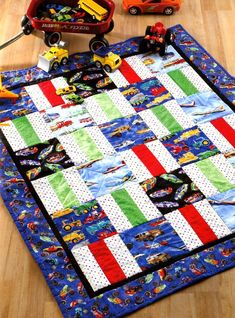 a play mat with cars and trucks on it, sitting on the floor next to toys