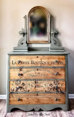 an old dresser with a mirror on top and writing on the drawers in french script