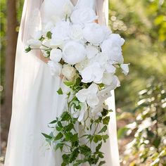 a bride holding a bouquet of white flowers