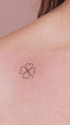 a woman with a four leaf clover tattoo on her chest