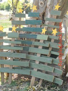 a wooden christmas tree made out of old wood planks with stars on it and text overlay that reads scrap wood christmas trees