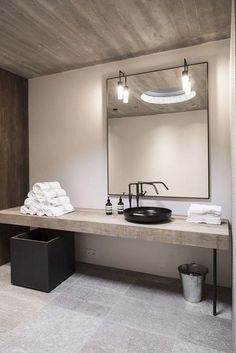 a bathroom with a sink, mirror and towel rack in it's center area