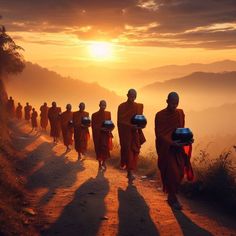 several monks walking down a dirt road towards the sun in the distance with buckets on their heads