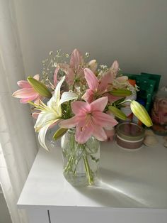 a glass vase filled with pink and white flowers