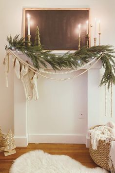 a fireplace decorated for christmas with candles and stockings on the mantel, next to a white sheepskin rug