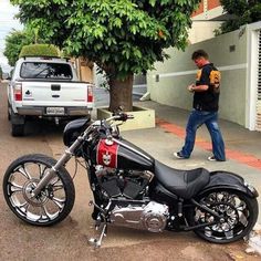 a man walking past a parked motorcycle on the street