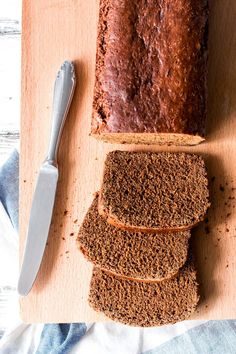 a loaf of bread sitting on top of a wooden cutting board next to a knife