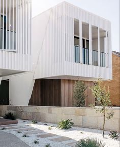 a white building with two balconies next to it