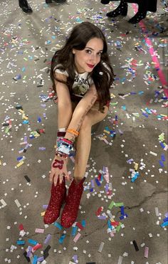 a woman sitting on the ground surrounded by confetti