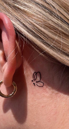 a close up of a person's ear with a tattoo on it