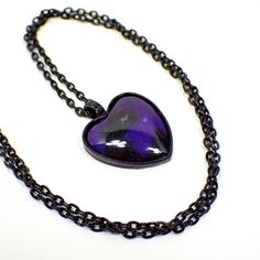 Nice Goth heart design with black chain and setting. The resin cab is pearly black with a bluish pearly purple that can be more purple or more blue in color depending on how the light hits it. Size: Chain is 24" long. Pendant is 1 3/8" x 1" in size including the bail. Type: New, Handmade by Sharky.  Condition: Made with all new materials. Please note that handmade resin pieces may include small imperfections and slight differences in pattern and color. Materials: Black coated base metal, resin. Gothic Heart Necklace As Gift, Gothic Heart Shaped Necklace As Gift, Gothic Heart Shaped Necklace For Gifts, Emo Heart-shaped Jewelry Gift, Emo Necklace For Valentine's Day Gift, Emo Style Necklace For Valentine's Day Gift, Handmade Emo Style Necklace As Gift, Handmade Emo Style Necklace For Gift, Purple Resin