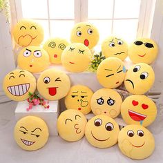 a group of yellow emoticions sitting on top of a white table next to a window