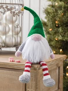 a crocheted gnome sitting on top of a wooden table