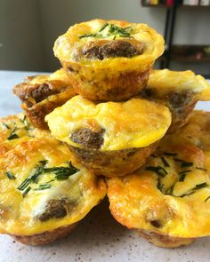 several muffins stacked on top of each other with meat and cheese in them