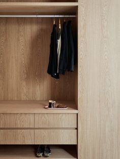 a wooden closet with clothes hanging on it