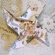 an origami star with fairy images on it is sitting on a lace doily