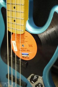 an electric guitar with a blue body and orange frets on it's neck