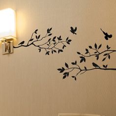 the wall is decorated with black birds on a tree branch, and there are two lights above it