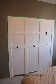 a bedroom with white doors and numbers on the wall