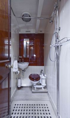 a bathroom with a sink, toilet and shower head mounted to the side of the wall