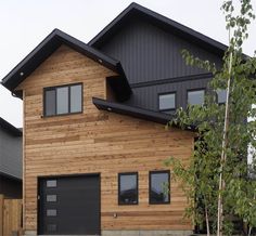 a wooden house with two garages on the front and one above the garage door