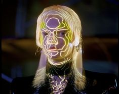 a woman with glowing face and hair in the middle of her body is looking at the camera