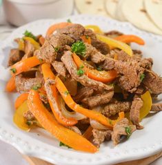 a white plate topped with meat and peppers