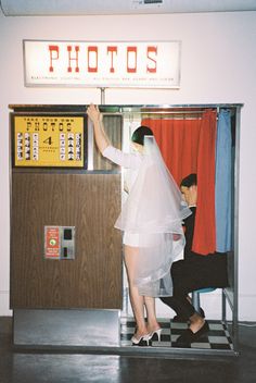 a man and woman standing in front of a photo booth